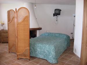 イーゾラ・ロッサにあるAlloggi Mare Sardegnaのベッドルーム(ベッド1台、テーブル、テレビ付)