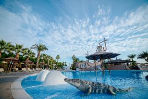 una estatua de un cocodrilo en una piscina en un complejo en Alannia Guardamar, en Guardamar del Segura