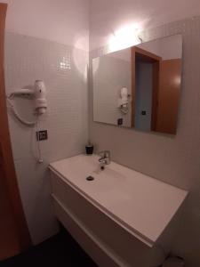 La salle de bains est pourvue d'un lavabo blanc et d'un miroir. dans l'établissement Vivienda Turistica La Catedral, à Santo Domingo de la Calzada