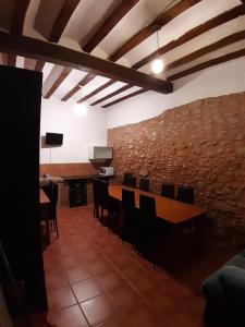 una stanza con tavoli e sedie e un muro in pietra di Vivienda Turistica La Catedral a Santo Domingo de la Calzada