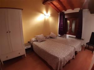 a bedroom with two beds and a dresser at Vivienda Turistica La Catedral in Santo Domingo de la Calzada