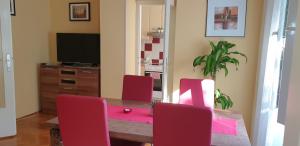 a dining room with a table and red chairs at 10 minutes walk to the lakes in Plitvička Jezera