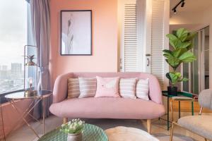 - un canapé rose dans le salon doté d'une fenêtre dans l'établissement Georgetown Tropicana 218 by Airlevate Suites, à George Town