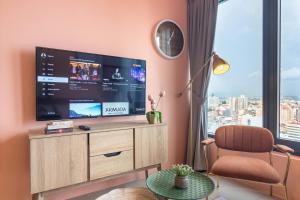 a living room with a large television and a chair at Georgetown Tropicana 218 by Airlevate Suites in George Town