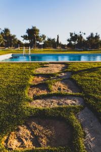 a walkway in the grass next to a pond at Vila Fuzeta Bed&Breakfast in Fuzeta