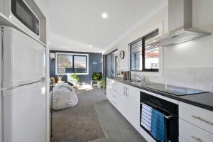 a kitchen with white cabinets and a stove top oven at Zoo Villas: Villa Giraffe - Central Wynyard in Wynyard