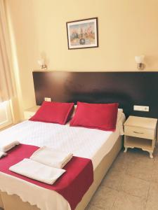 a bedroom with a large bed with red pillows at Dove Apart Hotel in Fethiye