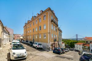 a building with cars parked in a parking lot at WHome | Premium River View Apartment in Lisbon