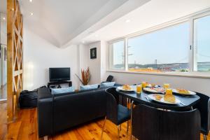 a living room with a couch and a table with food on it at WHome | Premium River View Apartment in Lisbon