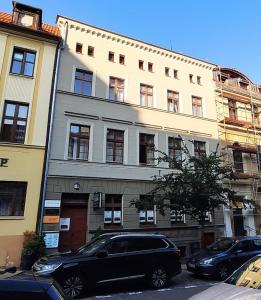 Czarny samochód zaparkowany przed budynkiem w obiekcie Glam Apartments w Toruniu