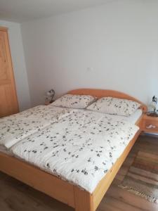 a bed in a bedroom with a wooden bed frame at Apartma pr´ Štengarju in Bohinjska Bela