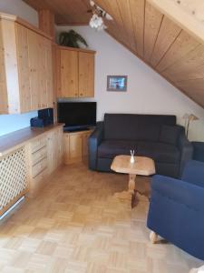 a living room with a couch and a table at Dachstein West Hotel GmbH-Kirchenwirt Russbach in Russbach am Pass Gschütt