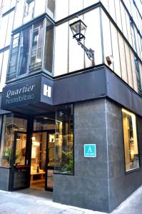 Quartier Bilbao Hostel في بلباو: محل امام مبنى عليه لافته