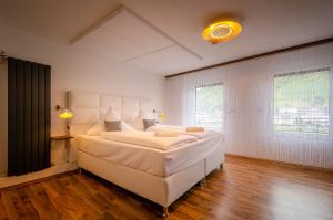 a large white bedroom with a large bed in it at MoselUnion - "schlafen & genießen" in Cochem