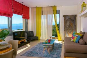 a living room with a couch and a tv at Anemos Elounda Villas in Elounda