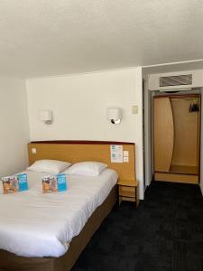 a hotel room with two beds with certificates on them at Kyriad Direct Marseille Ouest - Martigues in Martigues