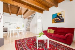 a living room with a red couch and a table at Tenuta Giardini Nuovi in Novoli