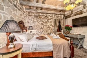 a bedroom with a bed and a stone wall at Historic Plaza Varos Split in Split