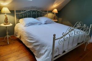a white bed in a room with two lamps at la maison de maxime in Courcelles-lès-Gisors