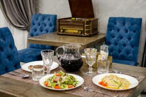 a table with two plates of food and glasses of wine at Boyarsky Dvor Inn in Dakhovskaya
