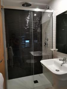a bathroom with a glass shower and a sink at Hotel Estrella del Mar in A Lanzada