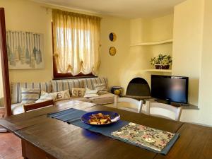 a living room with a table and a couch at Villa Soprana by Agenzia SolturElba in Capoliveri