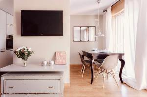 ein Esszimmer mit einem Tisch und einem TV an der Wand in der Unterkunft San Amaro Beach Apartment in A Coruña