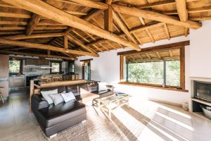 a living room with a leather couch and a fireplace at Lujosa casa en la Ribeira Sacra in Acova
