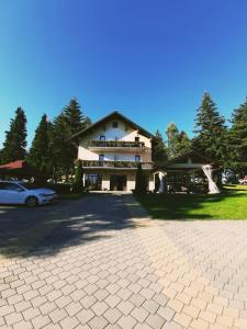 een groot huis met een auto ervoor geparkeerd bij Guest House Colovic in Zlatibor