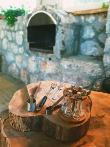 een houten tafel met zilveren bestek bovenop een boomstronk bij Guest House Colovic in Zlatibor