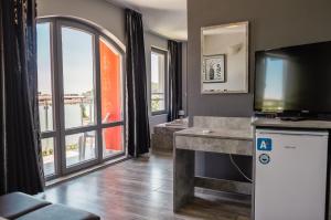 a living room with a tv and a large window at Calisto Villas Arapya in Arapya