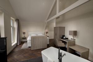 a hotel room with a bed and a desk at Hotel De Lindeboom in Den Burg
