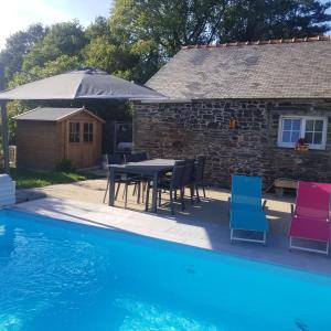 uma casa com uma mesa e cadeiras ao lado de uma piscina em Chambre d'hôtes Morbihan Gwenva em Sainte-Brigitte