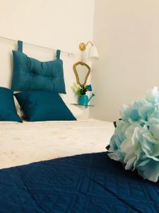 a bedroom with a blue bed with blue pillows at A Casa di Claudia in Naples