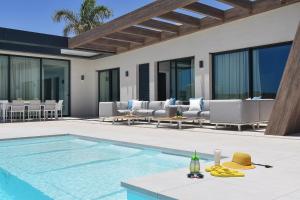 a villa with a swimming pool and lounge chairs at Salobre Sunset Villa V&L Salobre by VillaGranCanaria in Maspalomas