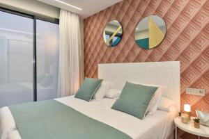 um quarto com uma cama com dois espelhos na parede em Salobre Sunset Villa V&L Salobre by VillaGranCanaria em Maspalomas