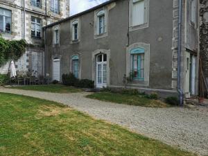 a building with a gravel driveway in front of it at Studio des Stuarts in Dol-de-Bretagne