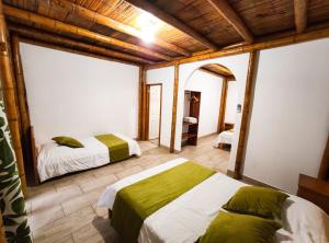 1 dormitorio con 2 camas y techo de madera en Tuzco Lodge, en Puerto López