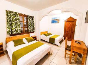 1 dormitorio con 2 camas, mesa y silla en Tuzco Lodge en Puerto López