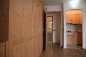 pasillo con puerta de madera en la cocina en Residence Miramonti, en Daiano