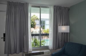 sala de estar con ventana y silla azul en Opal Hotel & Suites en Orlando