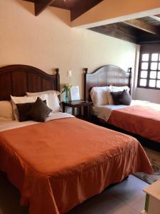 - une chambre avec 2 lits et une couette en orange dans l'établissement Bed and Breakfast Pecarí, à Cancún