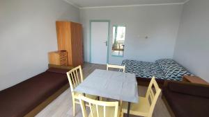 a bedroom with a bed and a table and chairs at Pokoje blisko morza przy promenadzie in Kołobrzeg
