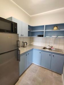 a kitchen with blue cabinets and a stainless steel refrigerator at Pokoje blisko morza przy promenadzie in Kołobrzeg