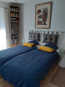 Saint-Cézaire-sur-SiagneにあるLe bois bouquetのベッドルームに青いシーツが備わるベッド2台