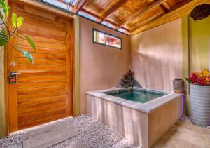 a hot tub in a room with a wooden door at Hotel Banana Azul - Adults Only in Puerto Viejo