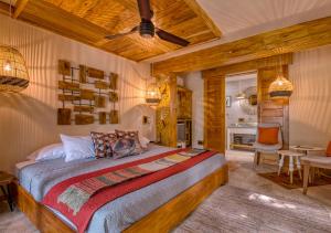 1 dormitorio con 1 cama, mesa y sillas en Hotel Banana Azul - Adults Only, en Puerto Viejo