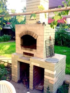 un horno de pizza de ladrillo en el patio trasero de una casa en Однажды в Одессе en Odesa