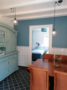 een eetkamer met een tafel en een slaapkamer bij B&B d'n Uilenhof Haren in Haren