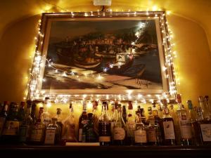 a display of bottles of wine under a painting with lights at Locanda Miranda in Tellaro